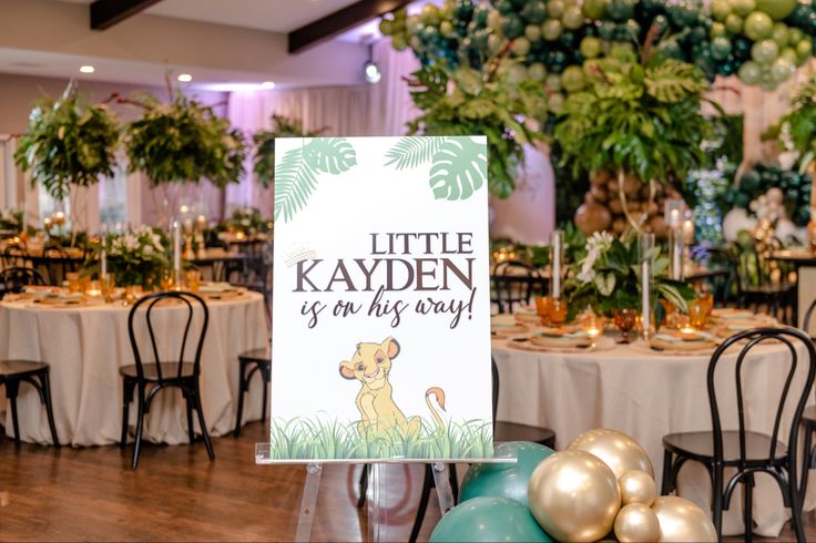 there is a sign that says little kayden is on the table with other decorations