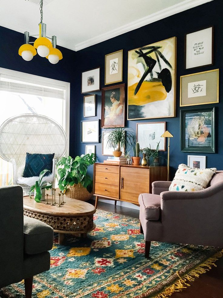 a living room with blue walls and pictures on the wall, including an area rug