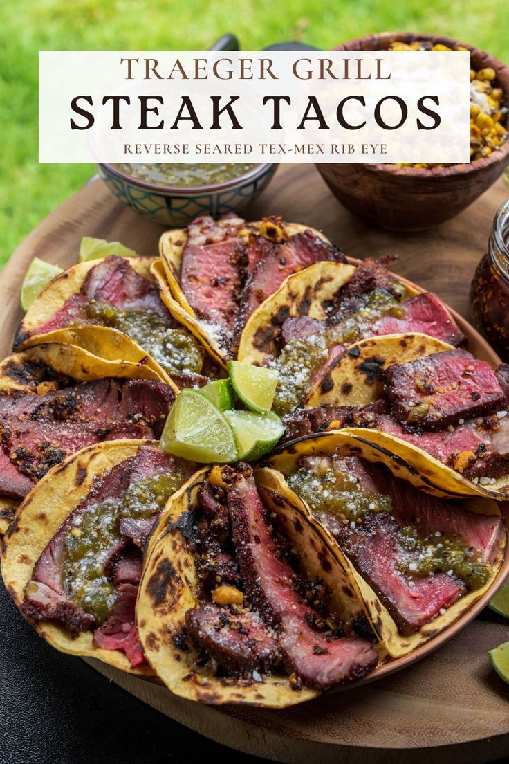 steak tacos on a wooden platter with limes and salsa in the background