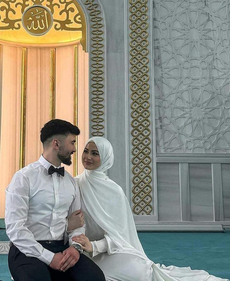 a man and woman dressed in white sitting on the ground