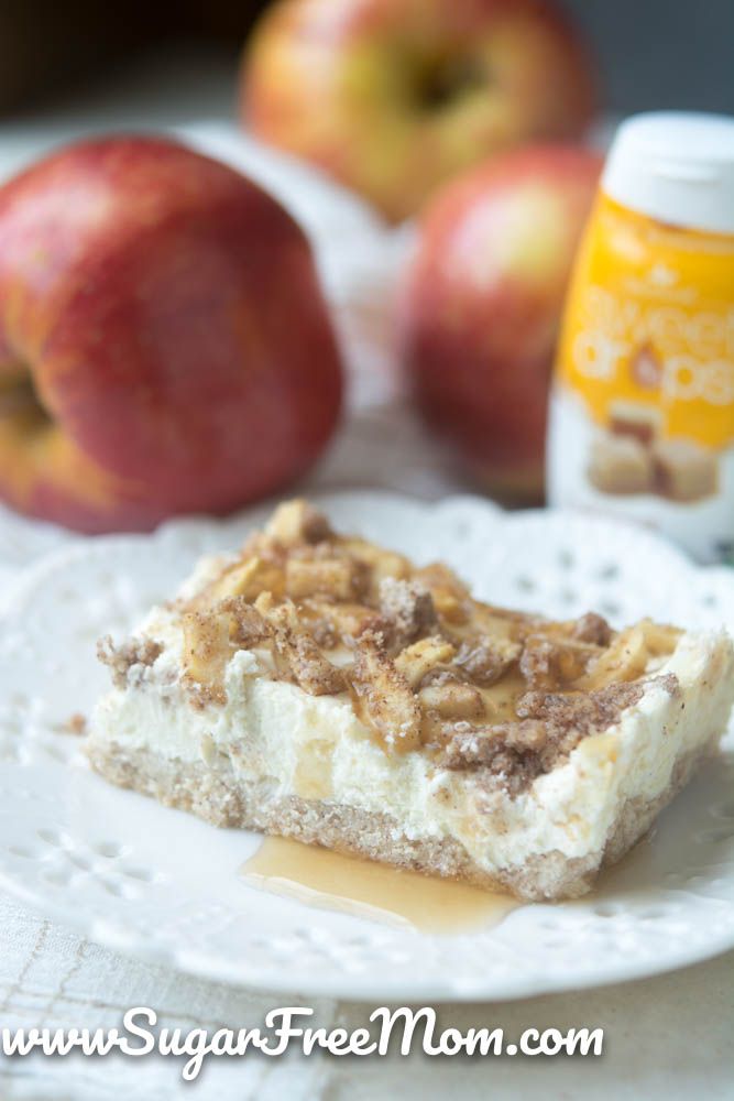 a piece of dessert sitting on top of a white plate next to two red apples