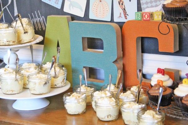 desserts and cupcakes are displayed on the table in front of an abc sign