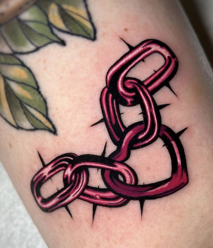 a close up of a person's leg with a tattoo on it and a chain