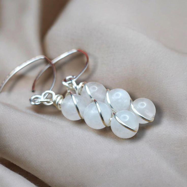 Glam up with our White Jade Dangle Earrings! Made with stunning white jade and intricately wrapped in silver wire, these boho-inspired earrings add a touch of elegance to any outfit. You'll be sure to turn heads with these unique dangle earrings (and maybe feel like a goddess too)! ;) Bohemian Sterling Silver Hand-wrapped Earrings, Bohemian Sterling Silver Hand Wrapped Earrings, Bohemian Silver Wire Wrapped Earrings, Silver Wire Wrapped Crystal Earrings As Gift, Silver Wire Wrapped Crystal Earrings For Gift, White Wire Wrapped Bohemian Earrings, Gift Silver Wire Wrapped Crystal Earrings, White Bohemian Crystal Earrings For Gift, White Bohemian Wire Wrapped Earrings