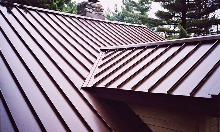 a brown metal roof with trees in the background