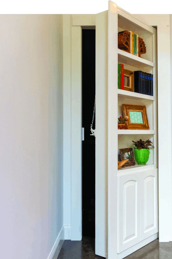 an open door leading into a room with bookshelves and pictures on the wall