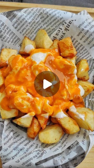 an image of a plate of food with cheese and potatoes in it on top of newspaper