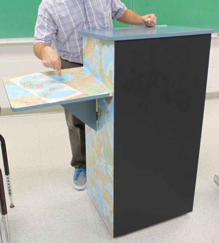 a man standing at a podium in front of a chalkboard