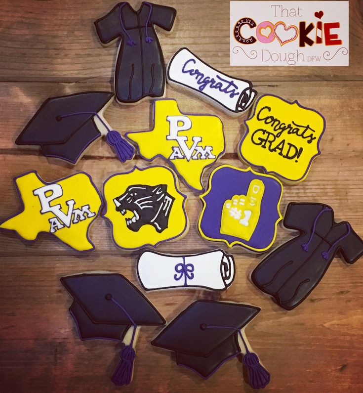 decorated cookies with graduation caps, gowns and tassels on a wooden table