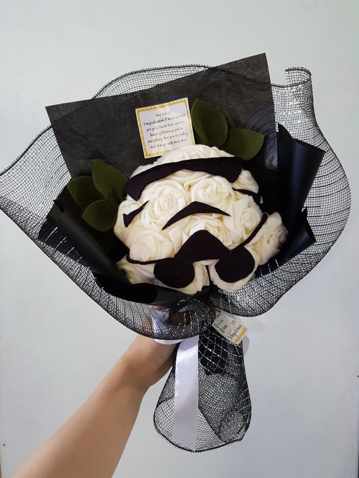 a hand is holding a black and white bouquet