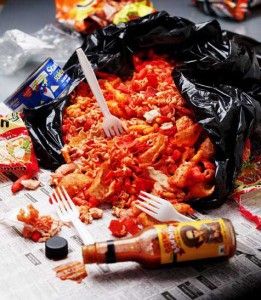 a pile of food sitting on top of a newspaper next to a fork and knife