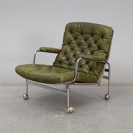 a green leather chair sitting on top of a white floor