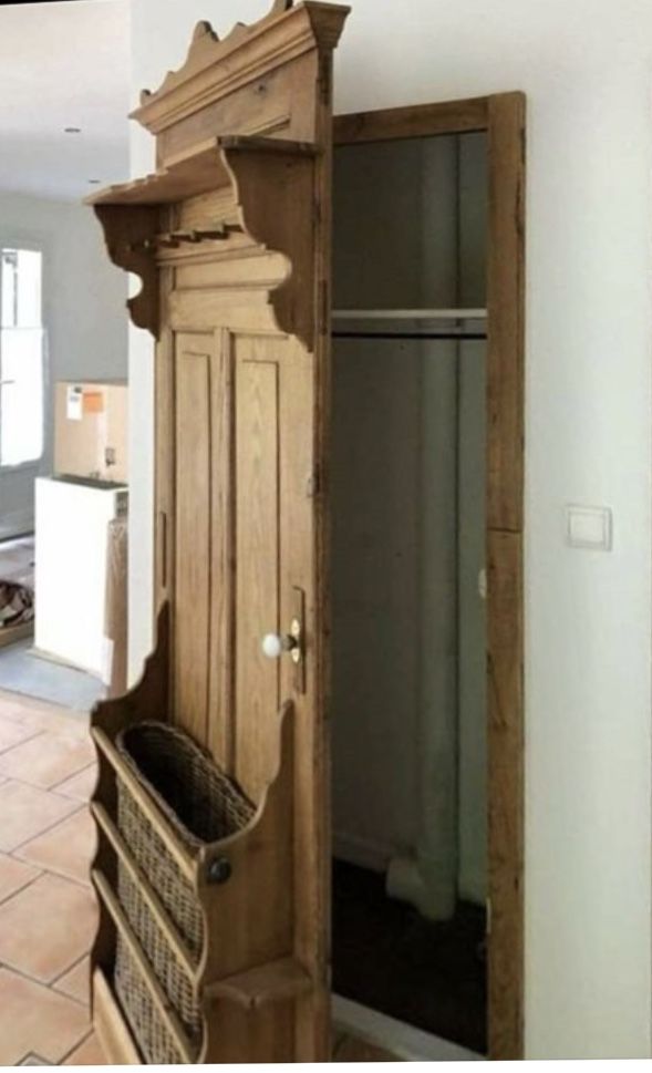 a wooden armoire sitting inside of a kitchen