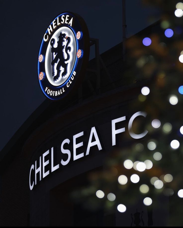 the chelsea football club sign is lit up at night