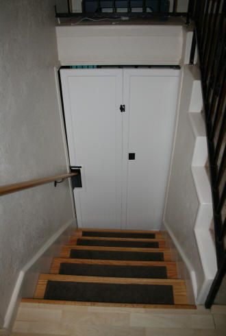 the stairs are made of wood and have black rugs on them, along with a white door