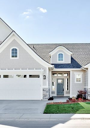 a white house with two garages and green grass