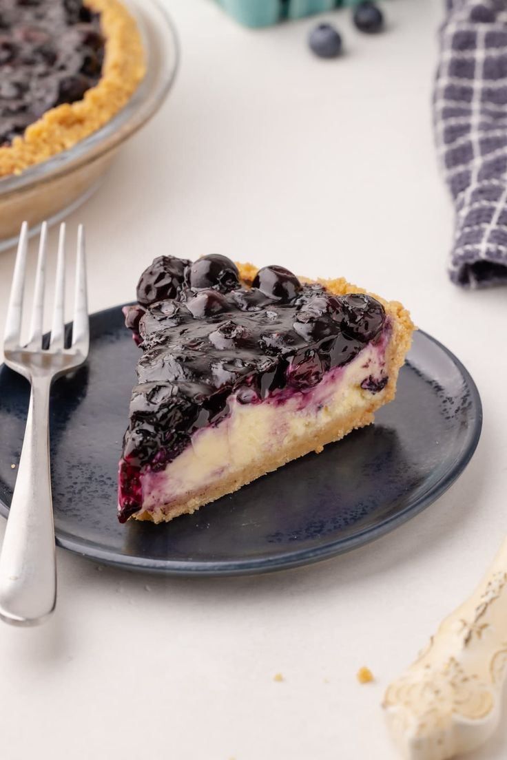 a slice of blueberry pie on a plate with a fork