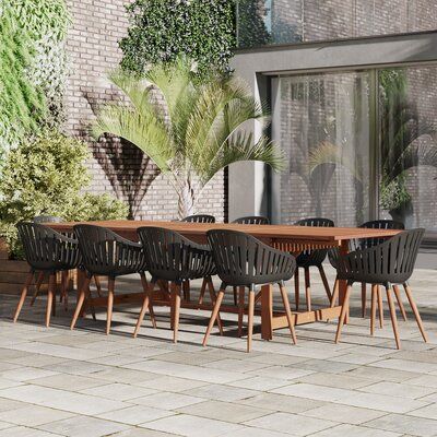 an outdoor dining table with six chairs and a potted plant in front of it