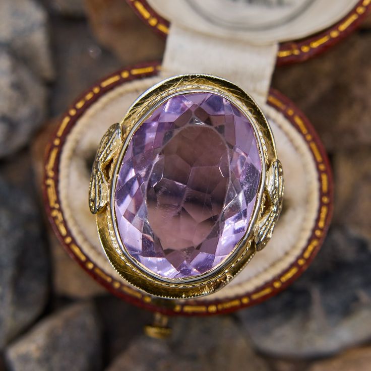 This detailed vintage amethyst ring is crafted in 14k white gold with a yellow gold plating and features a 10 carat bezel set oval cut lilac amethyst with a beautifully pierced under gallery and bow motif on each shoulder. The ring is currently fits like a size 5. The gemstone has light abrasion which is not distracting. Luxury Oval Amethyst Collectible Ring, Oval Amethyst Jewelry Collectible, Collectible Oval Cabochon Amethyst Ring, Heirloom Style Purple Oval Amethyst Ring, Oval Amethyst Collectible Ring, Oval Amethyst Ring With Bezel Setting For Formal Occasions, Antique Oval Purple Amethyst Ring, Antique Oval Amethyst Ring, Heirloom Oval Amethyst Jewelry