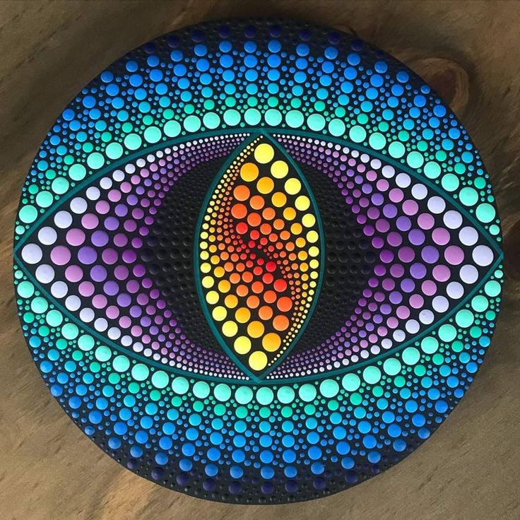 a colorful painting on a wooden surface with circles in the shape of an eyeball