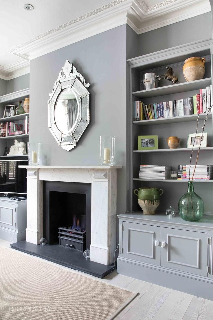 an image of a living room with fireplace and bookshelves on the shelves in it