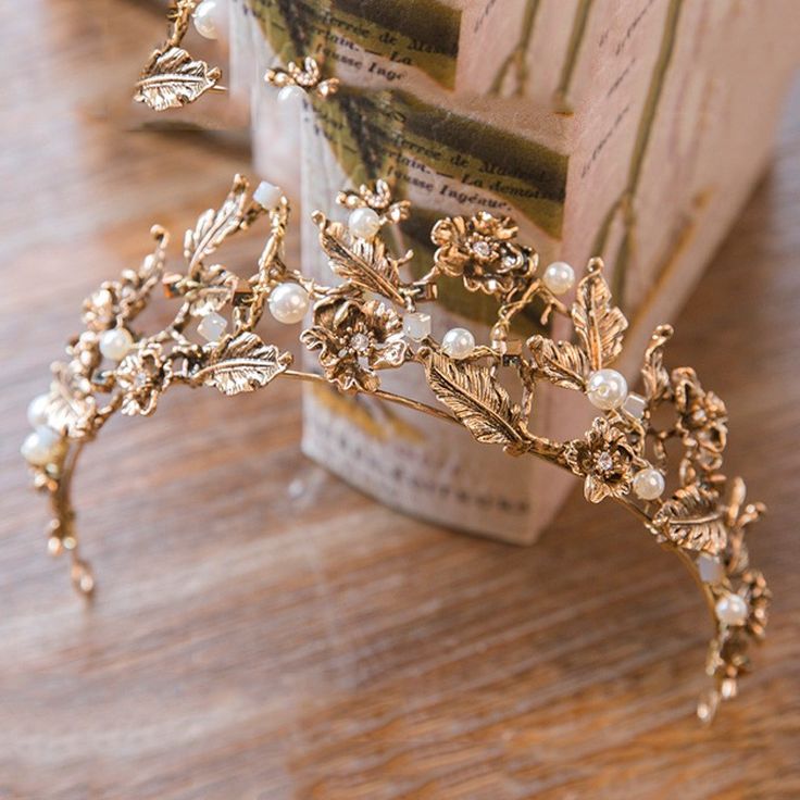 a close up of a tiara on a table with a book in the background