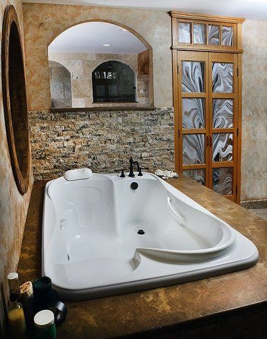 a large white bath tub sitting inside of a bathroom