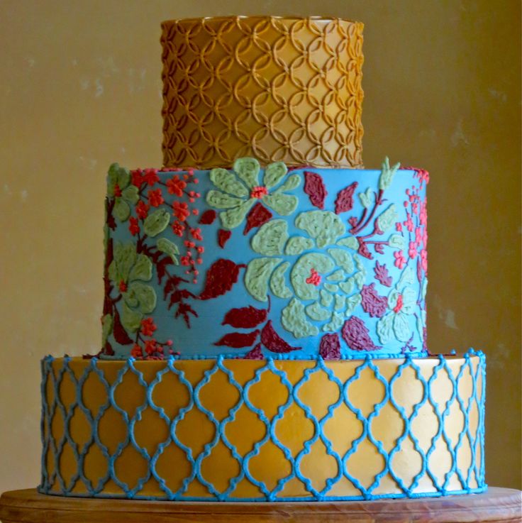 a three tiered cake with blue and yellow frosting