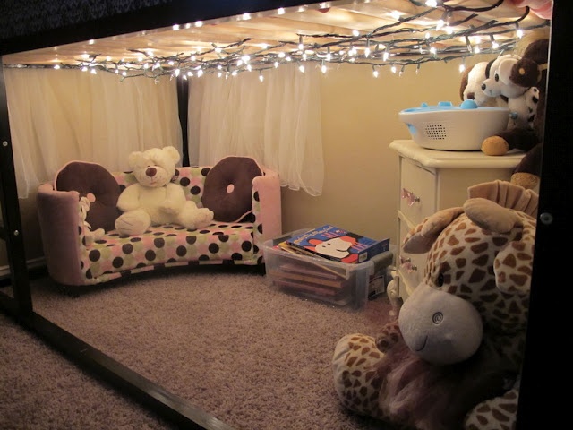 there is a stuffed animal in the corner of this room with lights strung above it