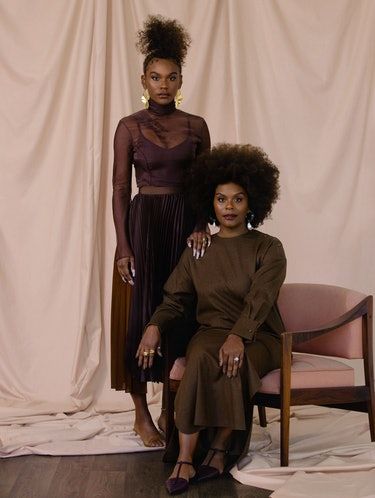 two women in brown outfits sitting next to each other