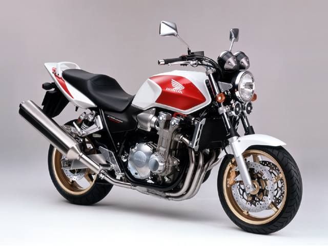 a red, white and black motorcycle is parked on a gray background in front of the camera