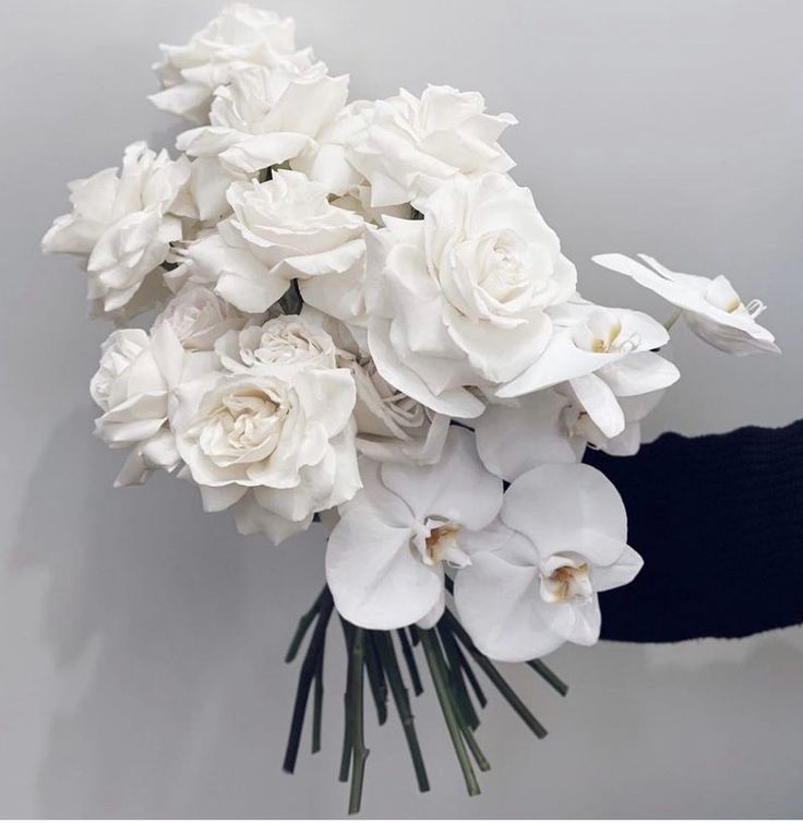 a bouquet of white flowers being held by someone