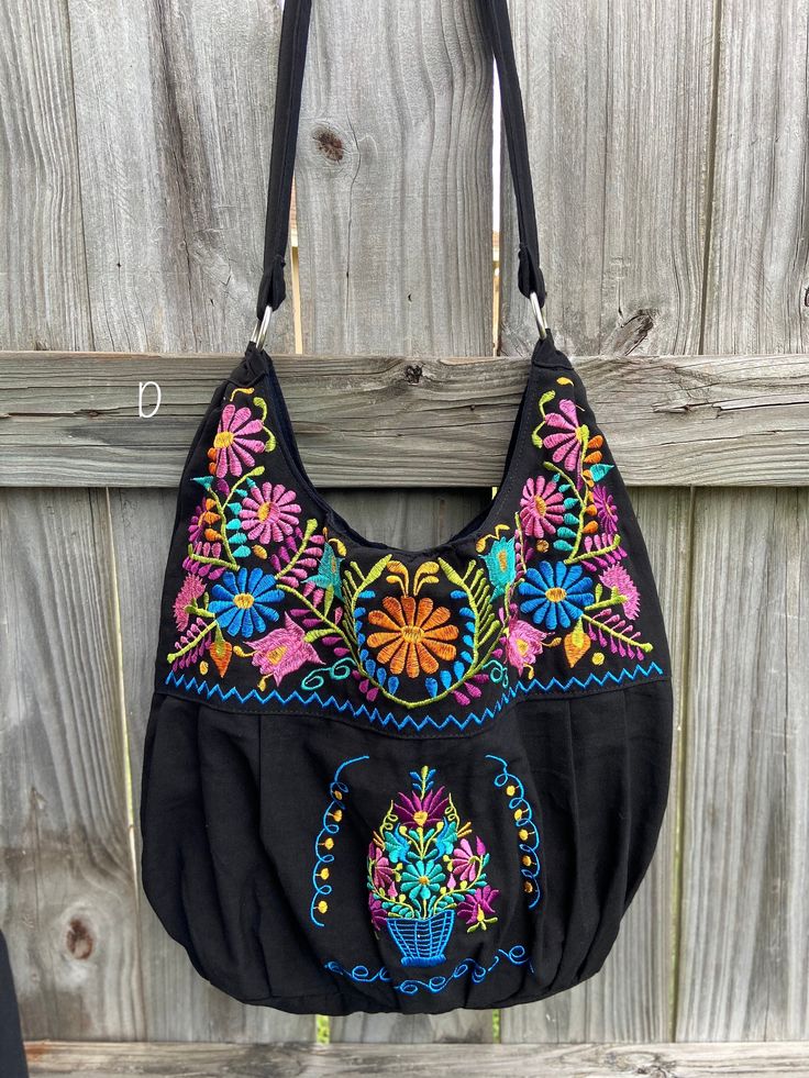 "Super Cute Floral Embroidered Bag from Puebla, Mexico Overview *Thread material * Cotton Fabric *approximate measurements: 13\" from bottom to zipper area & 15-16 with if expanded *handmade *Design colors may vary per purse as all are embroidered with unique colors * Closure is zipper or magnetic button - you can specify in notes section @ checkout which one you prefer * One pocket inside Care *hand wash only *delicate care *hang dry Please email me your questions before buying. All of my i Bohemian Crossbody Bag With Floral Embroidery, Multicolor Embroidered Floral Crossbody Shoulder Bag, Multicolor Floral Embroidery Crossbody Shoulder Bag, Bohemian Cotton Bag With Floral Embroidery, Bohemian Cotton Bags With Floral Embroidery, Festival Multicolor Embroidered Hobo Bag, Everyday Multicolor Embroidered Bag, Black Embroidered Everyday Satchel, Black Bohemian Cotton Bag