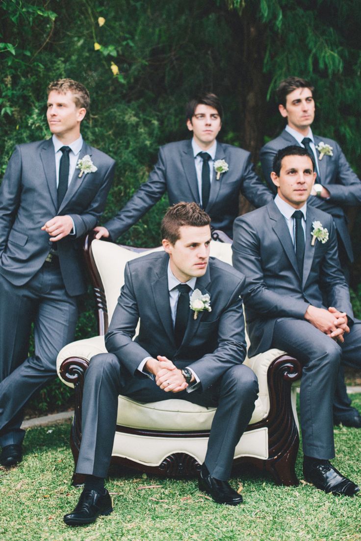 a group of men in suits sitting on top of a couch