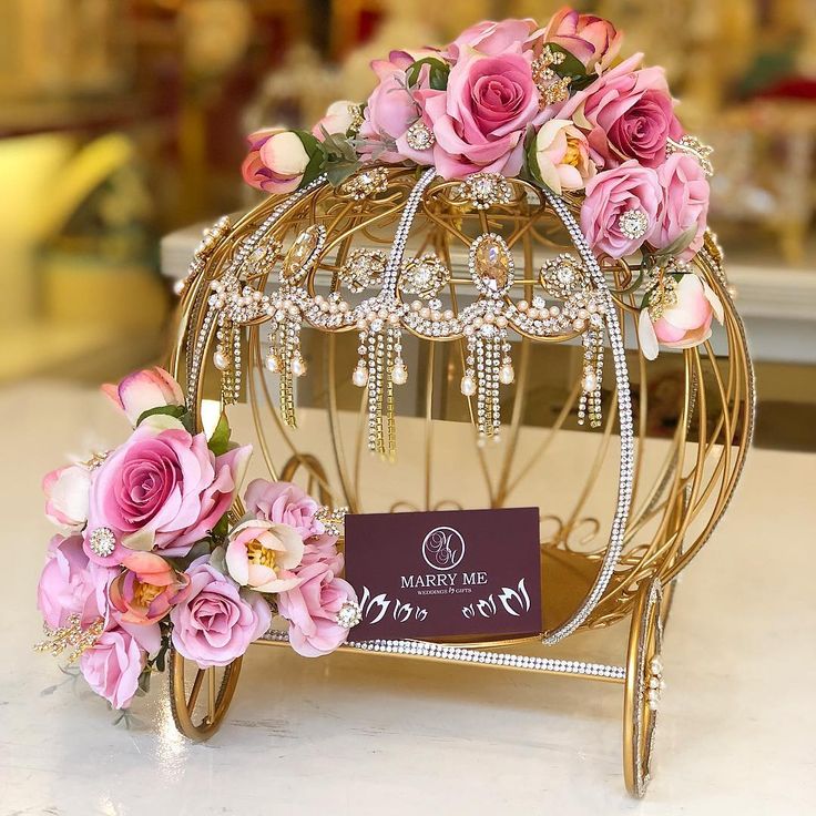 a birdcage filled with pink flowers on top of a table