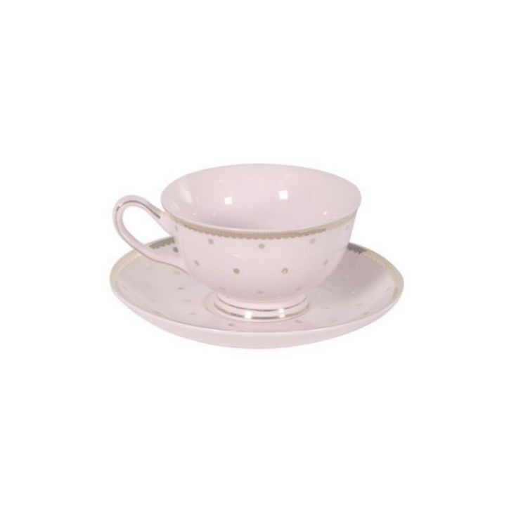 a pink cup and saucer with gold dots on the rim, sitting on a white plate