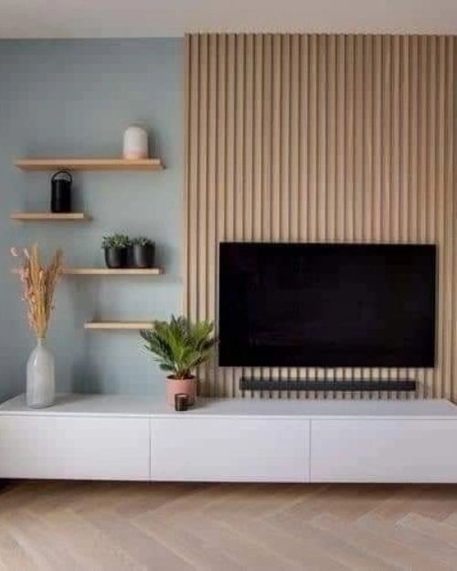 a living room with shelves and a flat screen tv on top of a white entertainment center