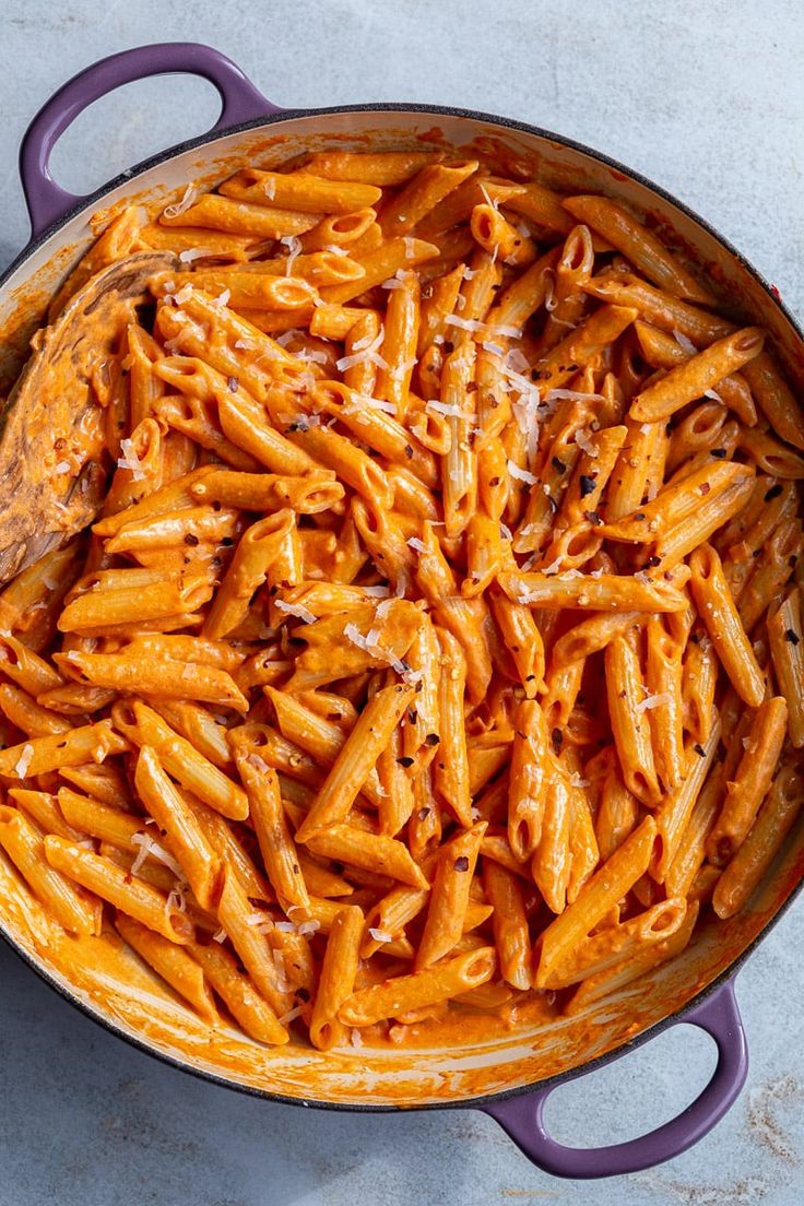 a pot filled with pasta and sauce on top of a table