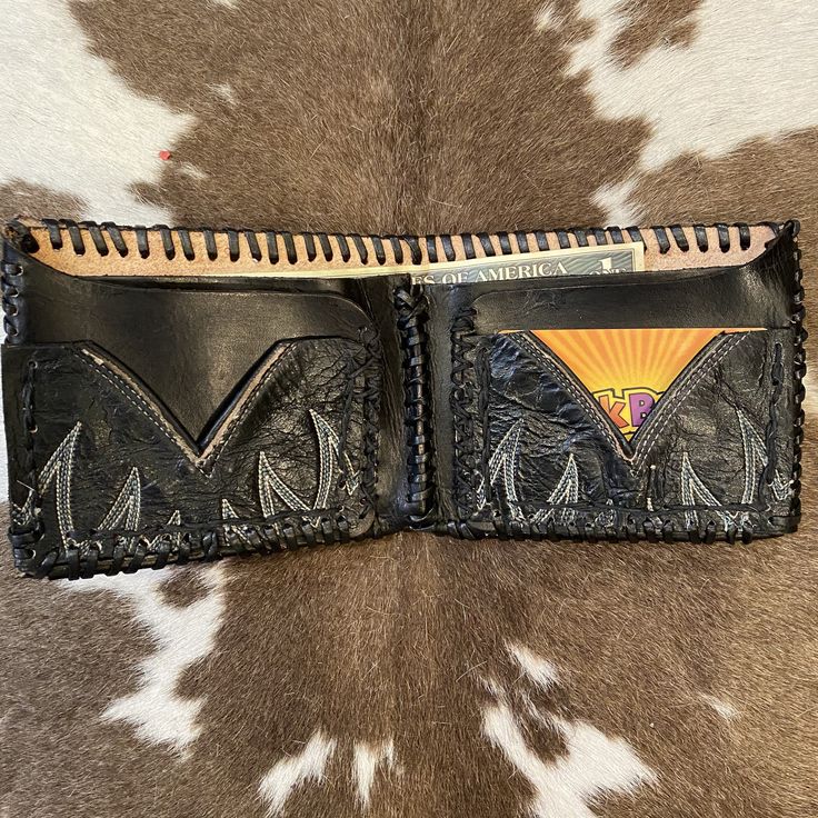 "I've taken a vintage black leather cowboy boot and turned it into a one of a kind wallet. Insert is genuine leather. Places for ID,credit cards, and cash. Hand stitched and crafted. Vintage and handmade items will not be perfect but I try to capture any flaws in photos. Would make a great gift for the cowboy or cowgirl in your life! Length open: 9 1/2\" Length folded: 5\" Width: 4\"" Hand-stitched Black Rectangular Wallet, Black Hand-stitched Rectangular Wallet, Black Rectangular Hand-stitched Wallets, Black Hand Tooled Bifold Wallet, Vintage Hand-tooled Leather Trifold Wallet, Vintage Hand Tooled Leather Trifold Wallet, Black Leather Wallet Hand-stitched, Hand-stitched Black Leather Wallet, Vintage Black Rectangular Trifold Wallet