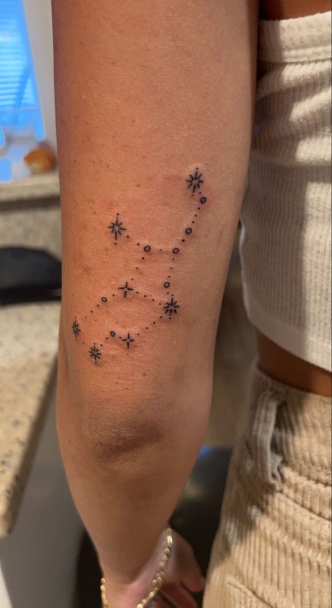 a woman's arm with small stars on it