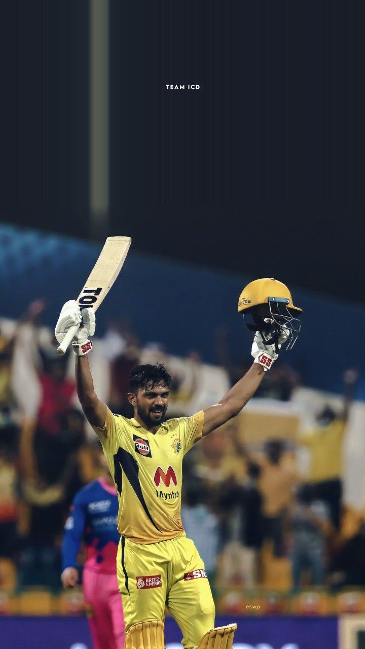 a cricket player holding his bat and helmet in the air with both hands up,