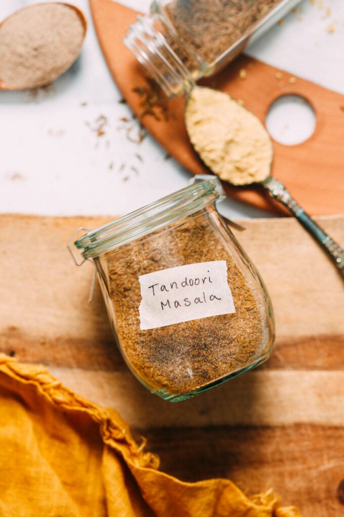 a jar filled with brown stuff sitting on top of a wooden cutting board