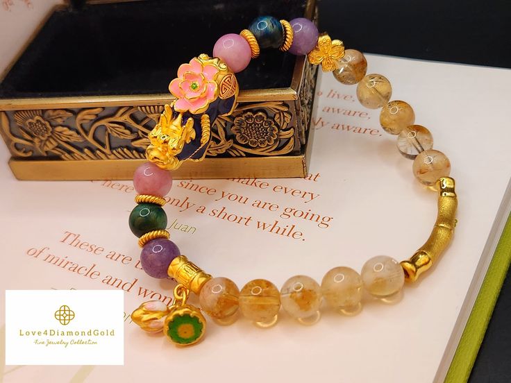 Gift yourself or your loveonce this beautiful Pure Gold Pixiu Bracelet. Pixiu changes color to green, blue, or bluish purple.  *Materials: Au999 Pure Gold, Citrine, , Lavender Jade, Tiger's Eye and  Agate. *Karat: 24K Pure Gold  *Gold Color: Yellow *Gold Weight: Approximately 5.58-5.81g Crystal/Gemstone: Approximately 8.8mm *Pixiu Length: 27.2mm / 1.07 Inch 🧧Pi Xiu has the meaning of bringing in wealth and treasure. Of course, it is capable of warding off evil spirits and bringing good fortune.  🧧the lotus flower symbolizes a very strong meaning of rebirth and/or enlightenment. Lotus flower purifies your heart and  mind that heightens your sense of joy and peace. It is also said to turn bad luck to good luck. 🧧Bamboo, according to Feng Shui attracts good luck and it is the symbol of gro Gold Spiritual Crystal Bracelet For Gift, Gold Crystal Bangle Bracelet For Gift, Gold Crystal Bracelet For Mother's Day, Gold Spiritual Crystal Bracelet For Wedding, Handmade Gold Crystal Round Bracelet, Handmade Gold Crystal Bracelet, Traditional Gold Bangle Crystal Bracelet, Traditional Gold Crystal Bangle Bracelet, Traditional Yellow Gold Beaded Bracelets As Gift