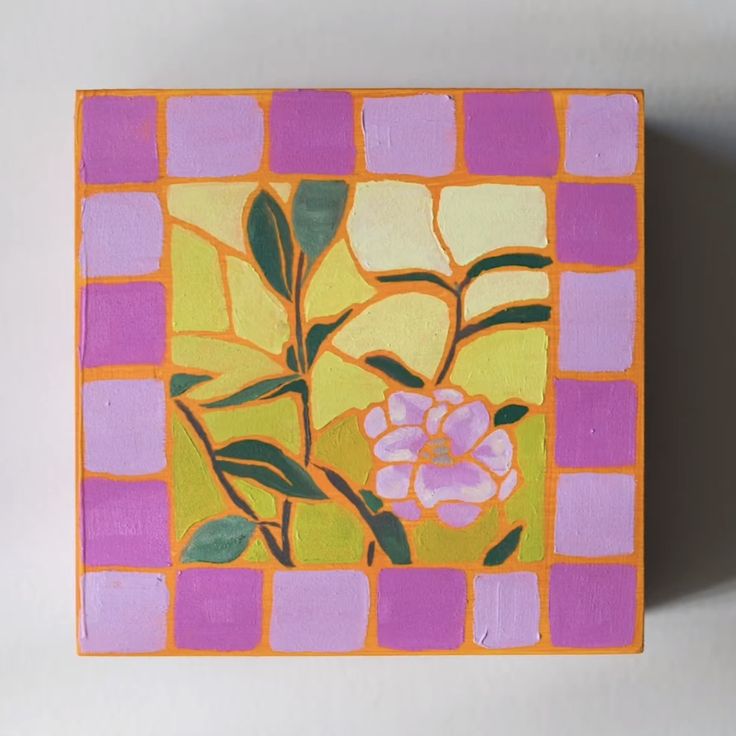 a small square painting with flowers painted on it