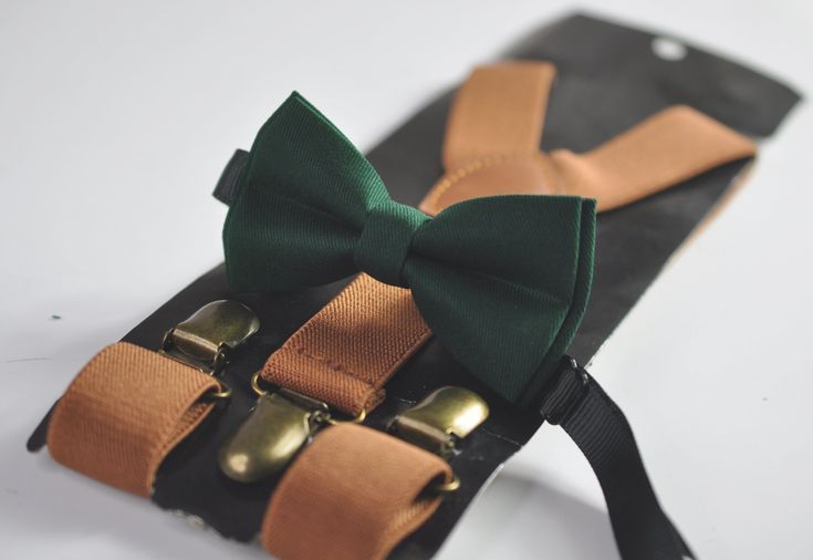 a green bow tie and two brown suspenders