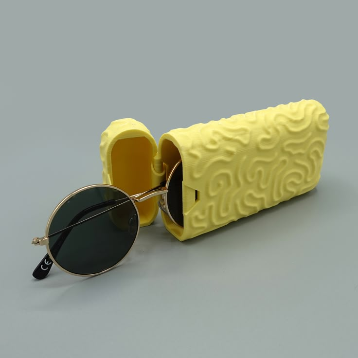 a pair of sunglasses sitting on top of a yellow case next to it's reflection