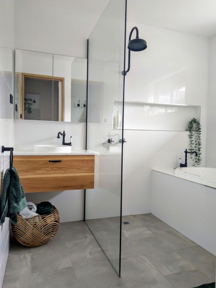 a bathroom with a sink, mirror and bathtub next to a shower head mounted on the wall