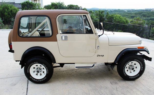 a white and brown jeep parked on top of a parking lot