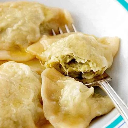 a white plate topped with dumplings and a fork