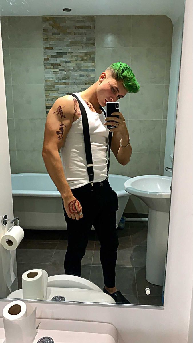 a man with green hair taking a selfie in the bathroom